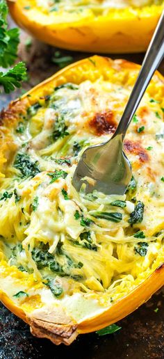 a spoon in a casserole dish with spinach and cheese on the side