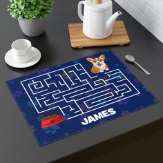 a dog themed rug with the name james on it next to a cup and saucer