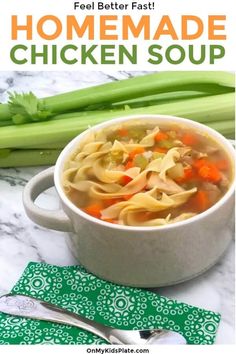 a bowl of chicken noodle soup with celery and carrots in the background