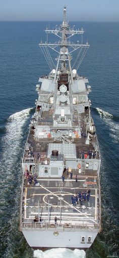 an aerial view of a large ship in the middle of the ocean with people standing on it