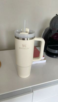 a white coffee cup sitting on top of a counter