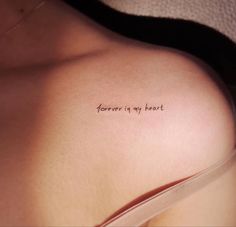 a woman's chest with the words forever in my heart tattooed on her left side