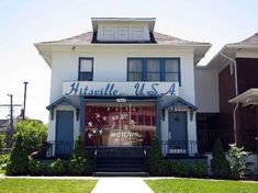 a large white house with blue shutters on the front door and windows that read, kitssville u s a