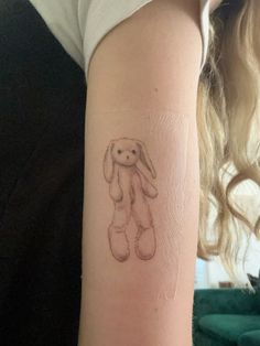 a small tattoo on the arm of a woman with a bunny rabbit in it's ear