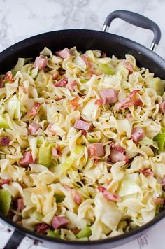 a skillet filled with pasta and ham