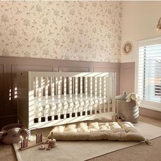 a white crib in a room with floral wallpaper