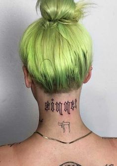 the back of a woman's head with tattoos on her upper and lower neck