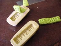 some green and white plastic objects sitting on a table next to a cutting board with the word jesus written on it