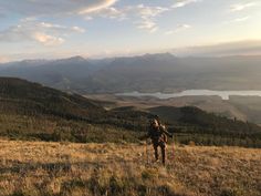 a man hiking up the side of a mountain with mountains in the backgroud