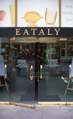 the entrance to an eatery with glass doors and menus on it's side