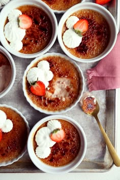 several small white bowls filled with food on top of a metal tray next to utensils