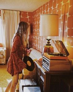 a woman standing in front of a table with a record player on top of it