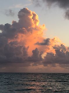 the sun is setting over the ocean with clouds in the sky and on the water