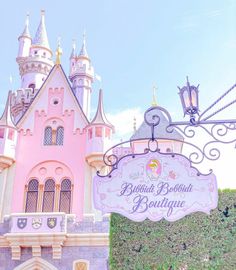 a pink castle with a sign in front of it