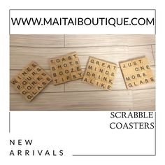 scrabble coasters with words on them sitting on a wooden floor in front of a white background