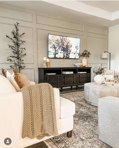 a living room filled with furniture and a flat screen tv mounted to the side of a wall