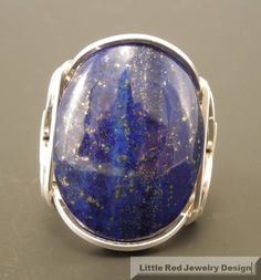 Handcrafted Sterling Silver Large Lapis Lazuli Cabochon Wire Wrapped Ring This style ring is often called a Pharaoh's ring due to the same style being found in the pyramids of Egypt. This ring is entirely handcrafted with sterling silver wire. I generally do wrap all the ring shank in order to increase the durability of the ring as well as comfort. However, I am listing each ring to have it your choice. You can see a picture of the plain vs the wrapped in the last picture. The ring has an 25 x 1 Round Lapis Lazuli Cabochon Rings, Lapis Lazuli Cabochon Rings, Handmade Adjustable Lapis Lazuli Rings, Handmade Lapis Lazuli Ring, Handmade Oval Lapis Lazuli Rings, Handmade Lapis Lazuli Rings Perfect For Gifts, Unique Lapis Lazuli Jewelry, Oval Lapis Lazuli Rings For Gift, Handmade Lapis Lazuli Jewelry For Anniversary