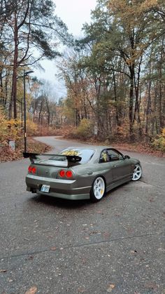 a car parked on the road in front of some trees