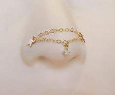 a pair of gold chain bracelets with charms