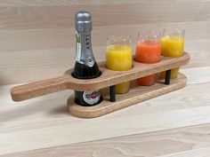 a wooden shelf holding glasses and bottles of juices on top of eachother