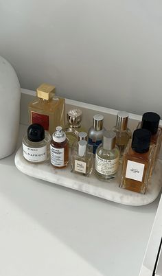 an assortment of perfumes on a white tray