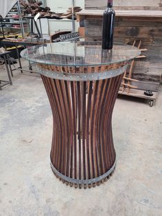 a wine bottle sitting on top of a glass table in a room filled with wooden pallets