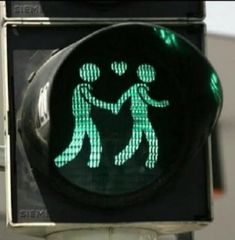 a green traffic light with two people holding hands