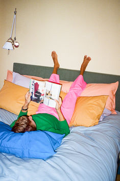 a person laying in bed reading a book