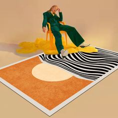 a man sitting on top of a chair in front of an orange and black rug