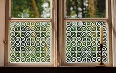 the window is decorated with green and white designs, as well as a candle in front of it