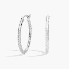 These small platinum hoop earrings have a subtly patterned, shimmer-cut surface that catches the light for just a glint of shine at the ear. The petite hoop size makes these earrings an everyday staple. Silver Diamond Cut Hoop Earrings, Modern Small Hoop Diamond Cut Earrings, Small Silver Hoop Earrings With Diamond Cut, Modern Round Diamond Cut Hoop Earrings, Silver Round Diamond Cut Hoop Earrings, Minimalist Sterling Silver Hoop Earrings With Diamond Cut, Modern White Gold Diamond Cut Huggie Earrings, Classic White Gold Hoop Earrings With Diamond Cut, Minimalist Sterling Silver Diamond Cut Hoop Earrings