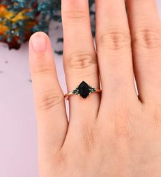 a woman's hand with a black diamond ring on it