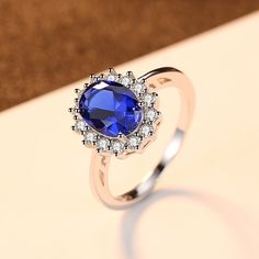 a ring with a blue stone surrounded by white diamonds