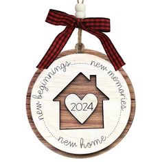 a wooden ornament with a house and heart hanging from it's side