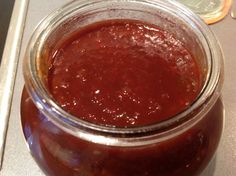 a jar filled with red sauce sitting on top of a counter