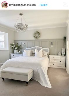 a white bed sitting in a bedroom next to a window