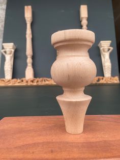 a wooden vase sitting on top of a table next to some other items in the background