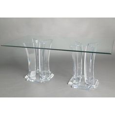 two clear vases sitting on top of a glass table