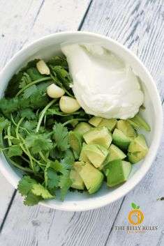 an avocado salad with sour cream and cilantro in a white bowl