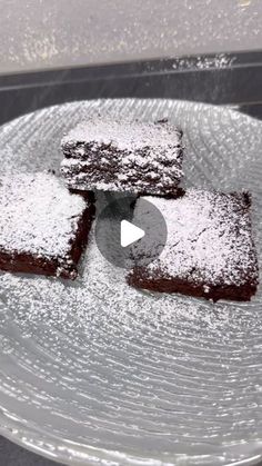 four pieces of cake on a plate covered in powdered sugar