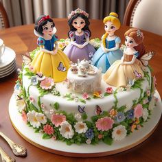 there is a cake decorated with princess figurines on top of the table and plates