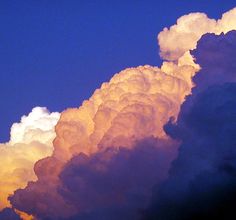 an airplane flying in the sky with clouds behind it