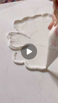 someone is making a paper angel craft with white paint on the surface and glue being applied to it