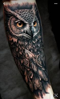 an owl tattoo on the arm is shown in black and grey colors, with orange eyes