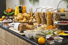 an assortment of breads, fruits and other food items on a countertop in a hotel room