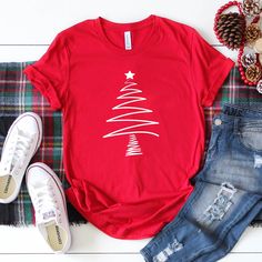 Womens Hand Drawn Christmas Tree Please Note: This Is A Unisex T Shirt So It Does Run A Little Bigger Than A Normal Woman’s Tee. If You Would Like A More Fitted Look Then Please Order A Size Down. Be Sure To Check The Photos For Exact Measurements. *Made By Ella + Brooks Co. In Texas, Usa *Pre-Shrunk *Machine Washable *100% Cotton *Bundle & Save Womens Funny Christmas Shirts If You Have Any Questions Or Need Assistance Please Feel Free To Reach Out. Follow Along @Ellaandbrooksco On Ig Vinyl Shirts Christmas, Cricket Christmas Shirts, Casual Festive Tops For New Year, Casual Red Top For New Year, Casual Graphic Print Tops For New Year, Casual T-shirt For Festive Holiday Season, Casual Holiday T-shirt For Festive Occasions, Casual Festive T-shirt For Holidays, Festive Casual Cotton T-shirt