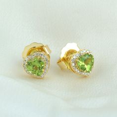 Exuding elegance, these unique stud earrings feature heart-shaped peridot gems set in lustrous 14K yellow gold. Adorned with pave diamonds, they sparkle with sophistication and charm. Perfect for adding a pop of color and luxury to any ensemble, these earrings are a stunning expression of style and individuality. This Earrings is handmade in 14k Yellow Gold : 2. 19 grams , and Diamond : 0. 19 cts ,Peridot: 1. 76 cts (OPS-21320)  This jewelry is made by hand featuring detailed workmanship. Be car Elegant Green Heart Cut Earrings, Elegant Green Heart Earrings For Gift, Valentine's Day Yellow Gold Gemstone Earrings, Elegant 14k Gold Heart Earrings With Birthstone, Elegant Peridot Earrings For Anniversary, Yellow Gold Peridot Earrings For Gift, Elegant Gold Heart Earrings With Gemstone, Diamond Heart Earrings, Unique Stud Earrings