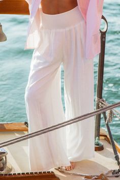 Elevated and breezy, these wide leg palazzo pants take beach chic to a whole new level. The Piscina Linen Pants can be styled as the perfect neutral base to a warm-weather outfit or as a beachside cover up. Featuring an ultra soft linen blend fabric, these flowy extra wide leg pants have a figure flattering smocked high waist, pockets and are fully lined. Product Details Material: 70% Rayon, 30% Linen. Lining: 100% Rayon.Fit: True to size. Length: 29" Inseam; 13" Rise (size Small). Fabric: Soft, Bohemian Summer Pants In Solid Color, Chic Linen Summer Bottoms, Bohemian Summer Pants, Solid Color Wide Leg Pants For Vacation, Solid Wide Leg Pants For Vacation, Relaxed Fit Wide Leg Pants For Vacation, Chic Bottoms For Day Out During Resort Season, White Pants For Beach Cover-up In Spring, White Beach Pants With Elastic Waistband