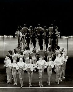 a group of women standing on top of a tennis court in front of an audience