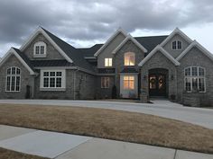 a large gray brick house with white windows